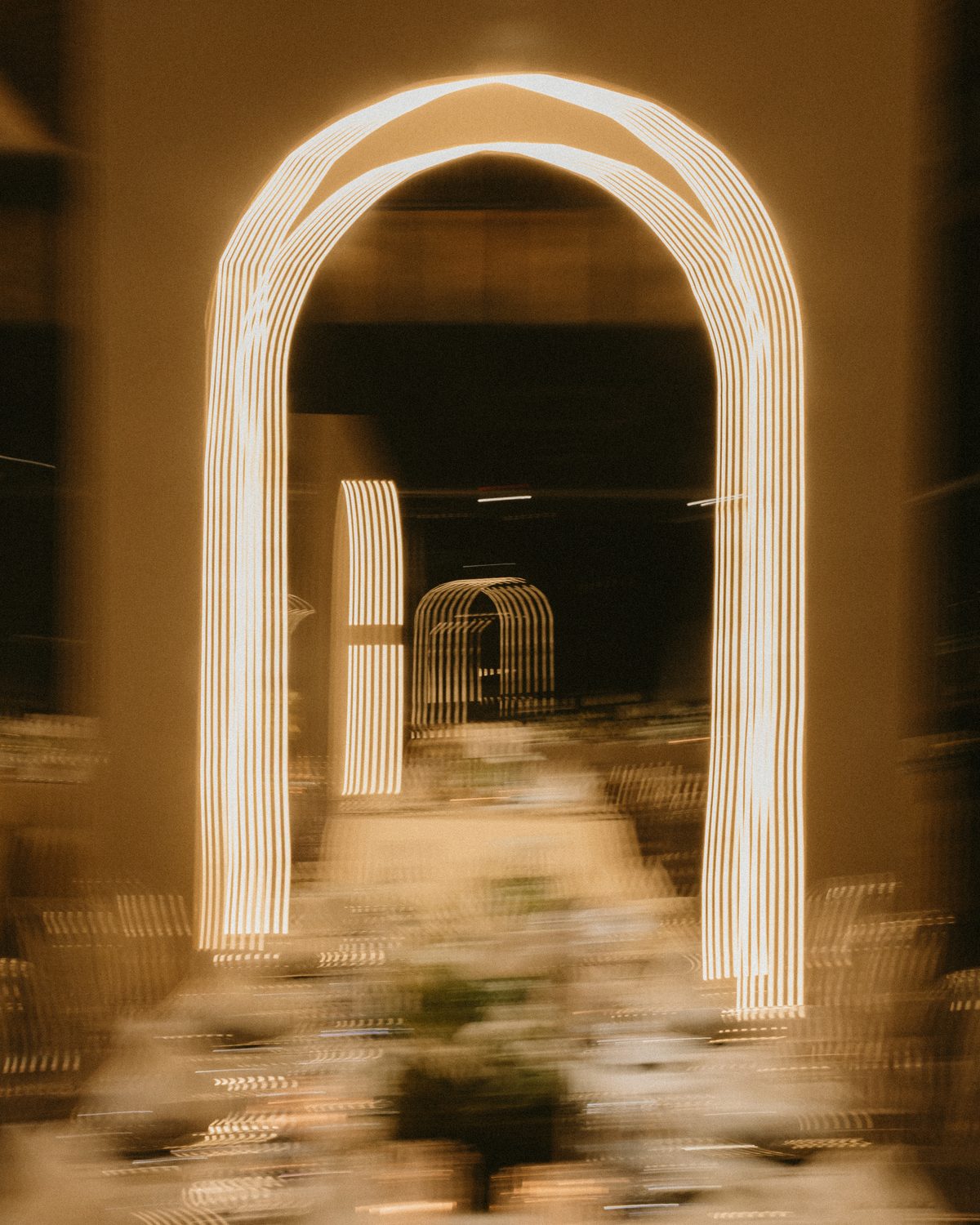 Un arco blanco trazado con luz, con el comedor suave y desenfocado detrás.